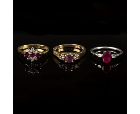 A ruby and diamond three-stone ring, the oval ruby with a baguette cut diamond to each shoulder, set in 18ct white gold, size