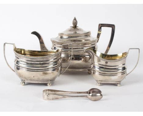 A George III silver three-piece tea set, William Hall, London 1806/07, of oblong form with ball feet, the teapot with pineapp