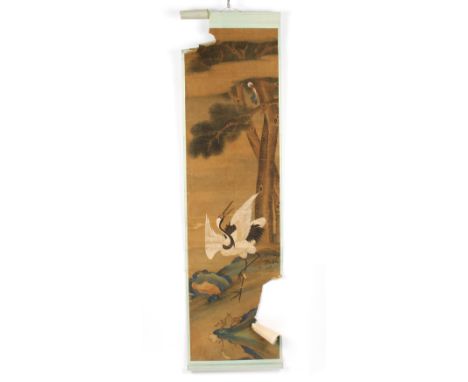 A Chinese scroll painting depicting a red-crowned crane amongst rocks and peonies with pine trees in the distance, 179cm x 48