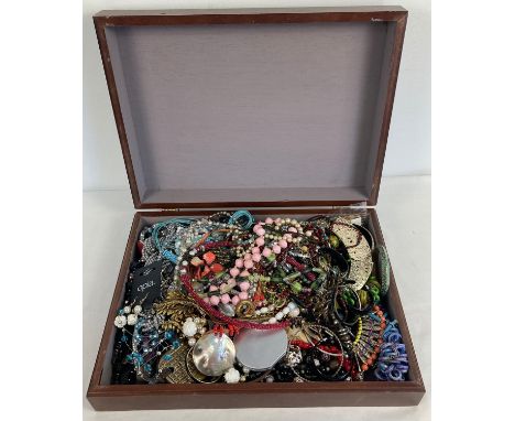 A large wooden box of mixed costume jewellery to include necklaces, bangle, bracelets and earrings. 