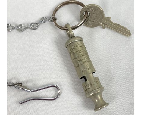 A vintage Hudson &amp; Co Metropolitan Police whistle, numbered 22633. On a key ring with a police box (tardis) key marked ET