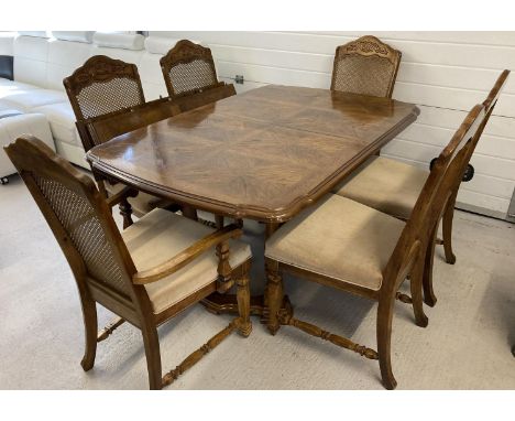 A vintage solid wood dining room table with 4 matching dining chairs and 2 carvers. Table has parquet effect design to top an