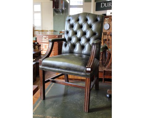 A late 19th Century green leather button back armchair with mahogany frame