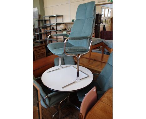 A vintage circular chrome and white melamine table with chrome and blue velour dining chairs