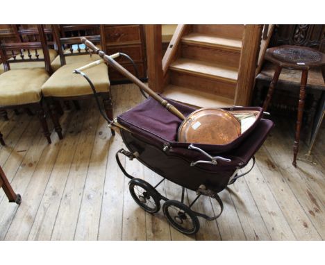 A vintage child's pram and a copper warming pan