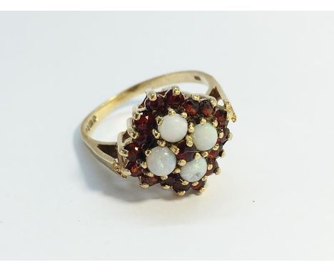 An Opal and Garnet Ring, hallmarked 9ct gold 1977, opals ETCW 0.80 ct. Ring size R, total weight 4.72 grams.