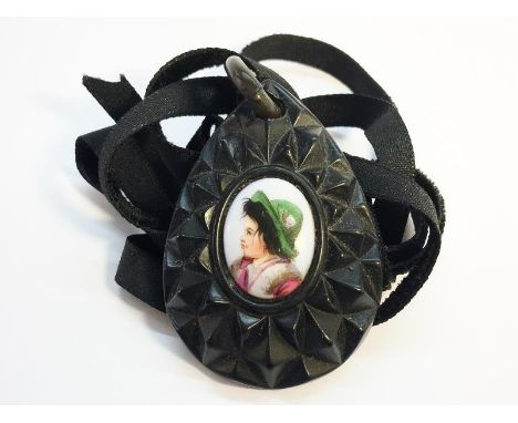 A carved Victorian Whitby Jet Pear shaped Pendant measuring approximately 5cm high, with an inlaid porcelain portrait of a yo