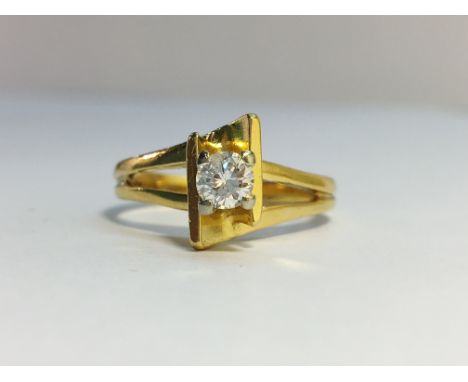 A Diamond single stone ring, circa 1970’s in 18ct yellow gold crossover mount with openwork shoulders. The ECW of the diamond