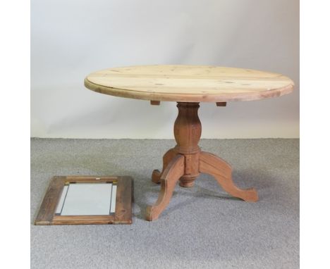 A pine circular dining table, on a tripod base, 175cm diameter, together with a pine framed wall mirror