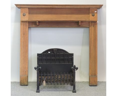 A 1920's oak fire surround, 136cm, together with a cast iron fire grate