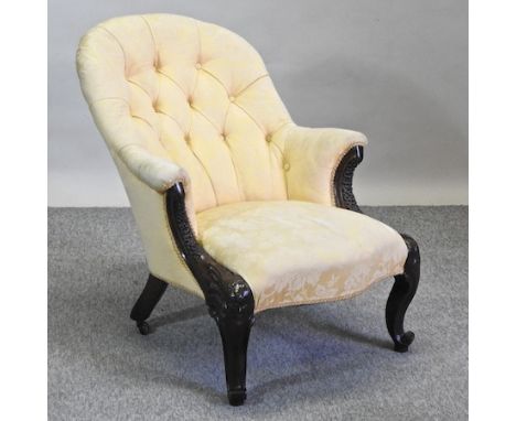 A Victorian carved mahogany and cream upholstered button back armchair