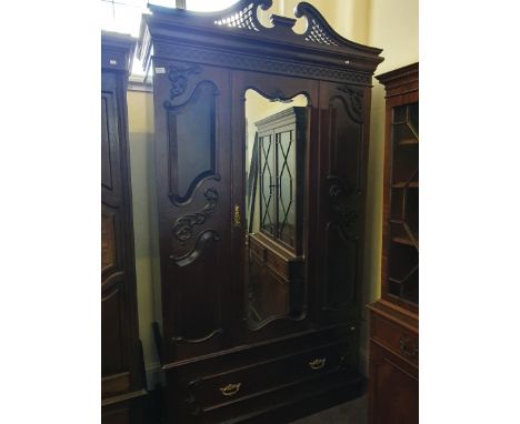 An Edwardian single mirror door wardrobe with a pierced top.