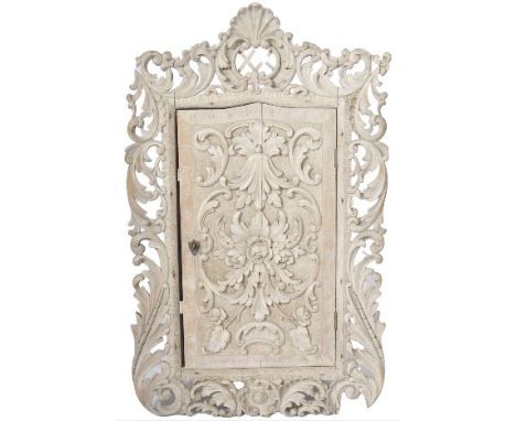 A late 18th Century George III carved walnut mural cupboard having a decorative carved pierced foliate surround with shell to