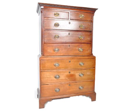 A 18th Century George III mahogany chest on chest of drawers having a flared pediment top with carved detailed work. The top 