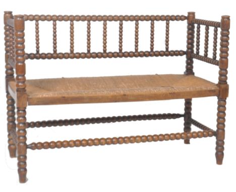 A 19th Century Victorian arts &amp; crafts window seat two seater bench having bobbin turned columns and supports. Rush seat 