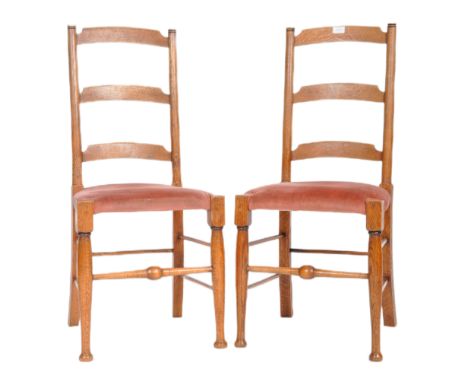 A pair of Arts and Crafts oak side / dining chairs, possibly by William Birch for Liberty &amp; Co. raised on ring turned leg