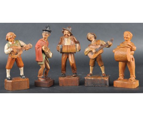 A set of five late 19th Century Victorian Black Forest carved musicians comprising two guitar players, two accordion players 