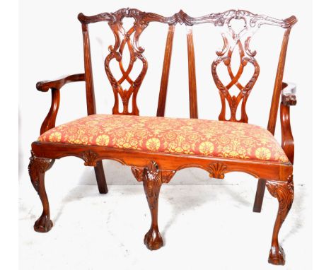 A 19th Century Victorian mahogany two seater bench of Chippendale influence having a carved and pierced back slates and scrol