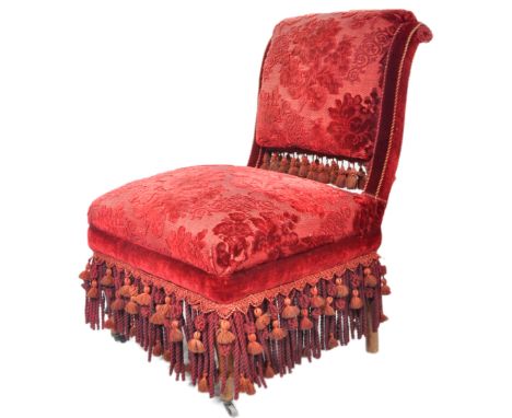 A 19th Century Victorian chair having a padded back and seat rest with red velvet floral upholstery with tasseled ends. All r