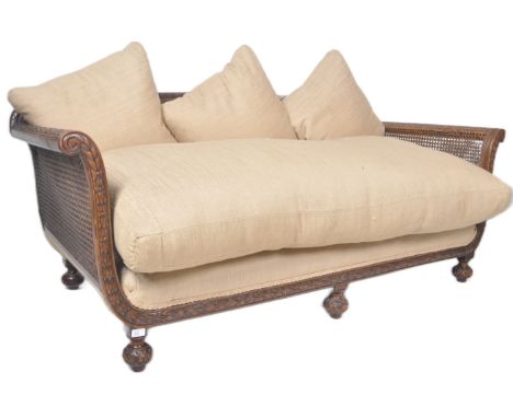 A 19th Century carved mahogany bergere sofa settee daybed. The sofa with carved frame and bergere sides having a large overst