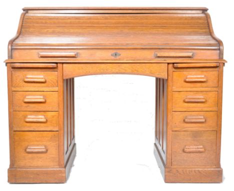 A 19th Century Victorian Lebus oak clerk's roll top desk, the tambour front opening to reveal drawers and recesses, above a c