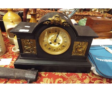 A Victorian slate mantel clock having eight day movement and a pair of gilt embossed panels 