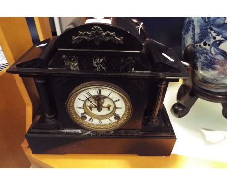 A Victorian slate mantle clock having enamel dial with Roman numerals