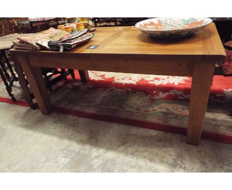 A modern light oak jointed extending dining table with breadboard ends, raised on chunky tapering supports