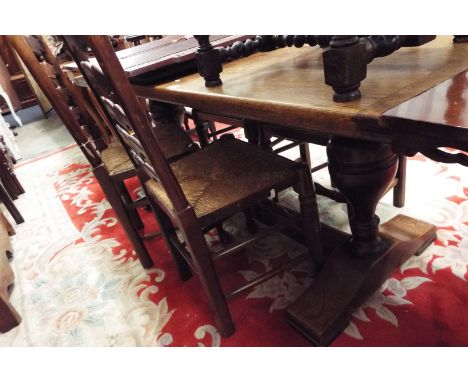 A 20thC oak refectory style dining table together with four oak ladder back chairs with rush seats