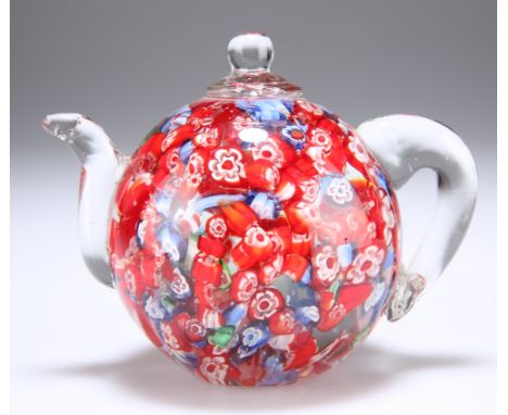 AN UNUSUAL GLASS PAPERWEIGHT IN THE FORM OF A TEAPOT,&nbsp;predominantly red canes but interspersed with blue and occasionall