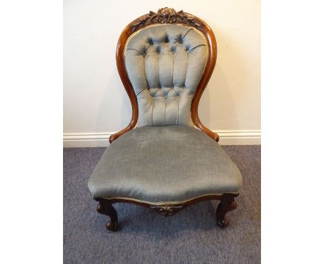 A mid-19th century mahogany show-wood framed and button-back upholstered nursing chair; raised on cabriole front legs termina