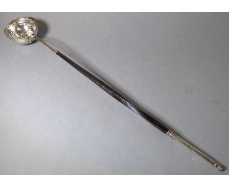 An 18th century white-metal toddy ladle, the base set with a Queen Anne shilling dated 1711(The cost of UK postage via Royal 