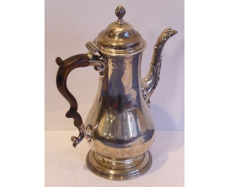 A large and heavy baluster-shaped hallmarked silver coffee pot; the wrythen-style finial above a hinged domed top and baluste