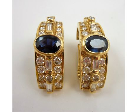 A pair of sapphire and diamond-set 'C'-scroll ear clips; each centrally-set with a sapphire collet above a tapering line of f