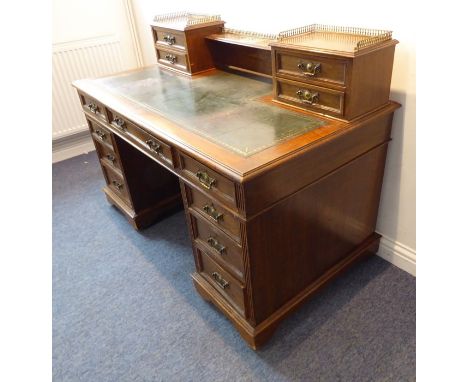 A late 19th century oak pedestal desk; the cross-shaped gilt-tooled green-leather inset moulded top, a shelved superstructure