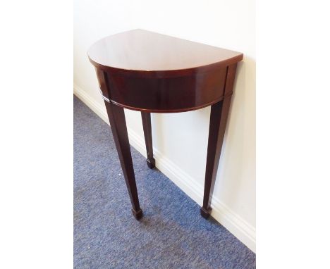 A demi-lune mahogany console table with crossbanded top above three square tapering legs terminating in spade feet (47.5cm wi