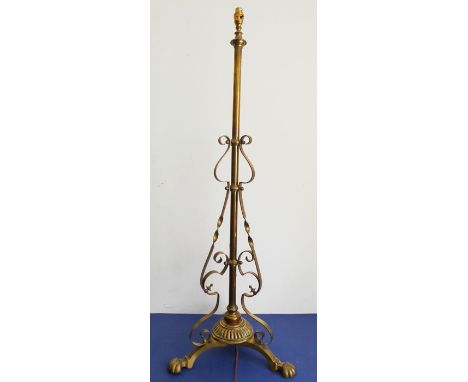 A heavy late 19th century hand-wrought brass lamp standard of ornate tripod design with adjustable height