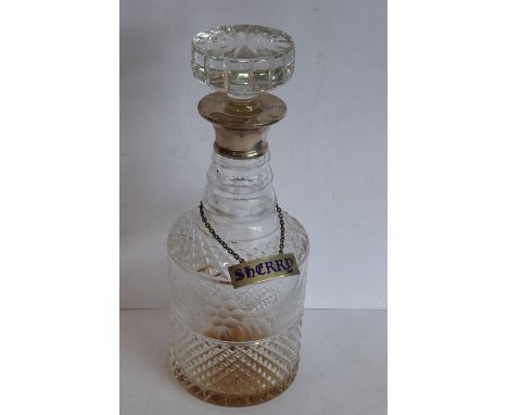 A cut-glass cylindrical decanter with mushroom-style stopper and hallmarked silver neck, also with hallmarked silver and enam