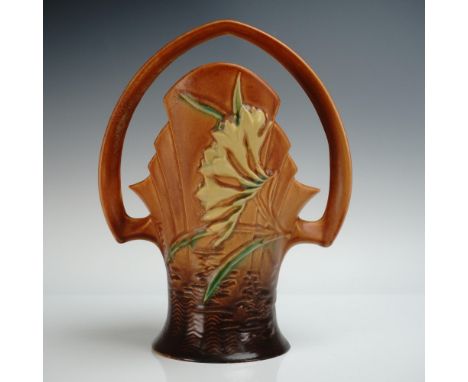 Striking Roseville art pottery basket in the Freesia pattern, form number 392-10, featuring sculpted yellow freesia blooms wi