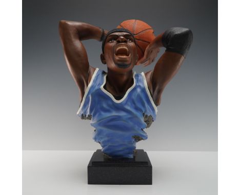 A dramatic resin sculpture of a basketball player mid dunk, sculpted in expressive detail with mouth open in a shout and both