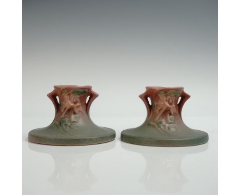 A pair of ravishing pottery candle stick holders perfectly decorated with a large bloom on slender stems with trailing leaves