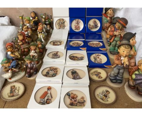 A large collection of Goebel figures after M.J. Hummel, of various sizes and collectors plates