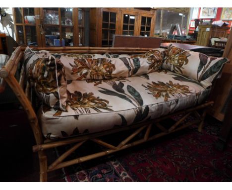 An unusual bamboo framed two seater sofa upholstered in 1950's floral fabric 