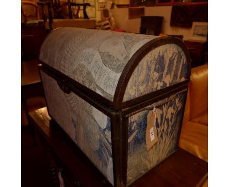 An iron bound domed top trunk upholstered in tapestry, with fall front 