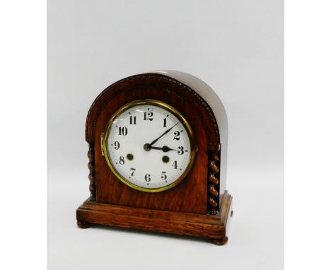 Oak cased mantle clock, the domed top over the enamel dial with Arabic numerals flanked by barley twist pilasters, 27cm high