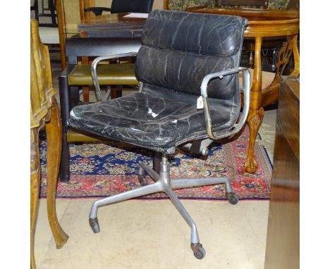 An early Charles Eames Hermann Miller soft Pad aluminium office chair in distressed black leather, with screw height adjustme