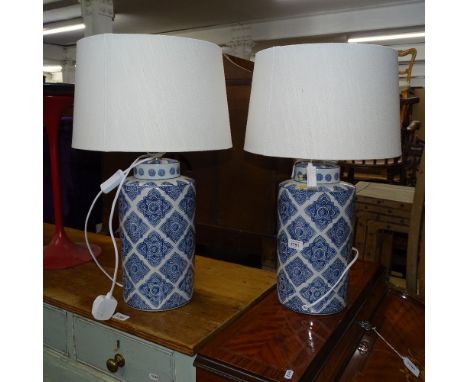 A pair of blue and white ceramic canister-shaped table lamps and shades 