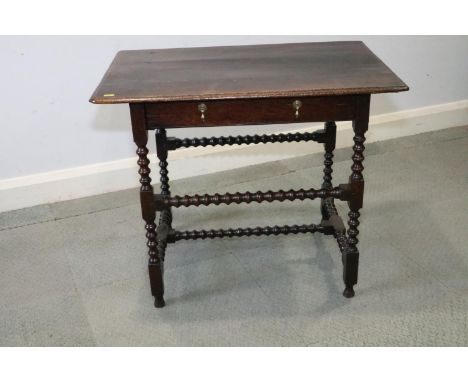 An 18th century oak side table, fitted one drawer with brass drop handles, on bobbin turned and stretchered supports, 30" wid