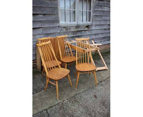 A set of four vintage Ercol "Goldsmith" high spindle back dining chairs with elm panel seats, on turned and stretchered suppo