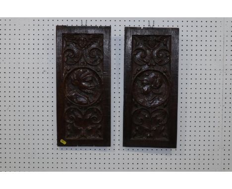 A pair of 16th century French? carved oak portrait panels with scroll work, 19" x 8 1/2"Condition:A few minor losses to edges